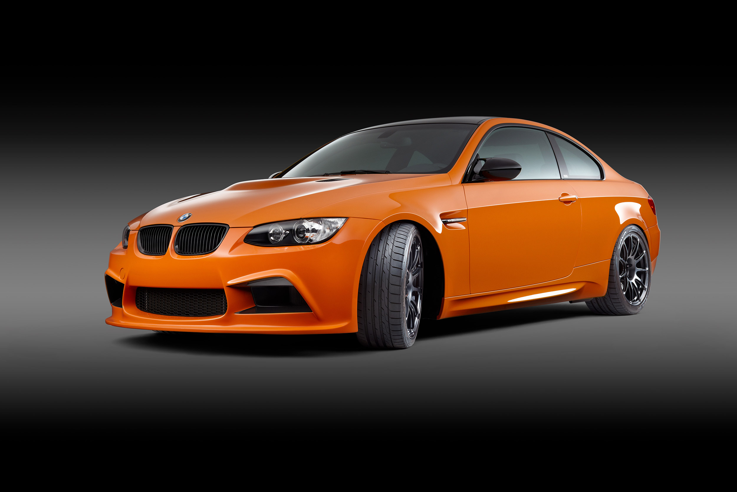 John Early High-End Digital Retouching - Bright Orange BMW M3 on a Dark Studio Background
